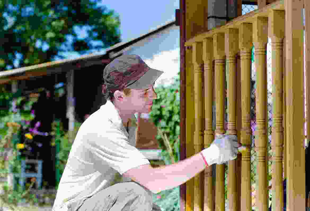 A man working on a wooden railing.