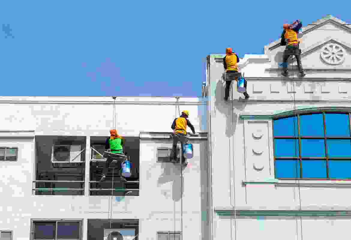 A group of workers cleaning the windows of a building.
