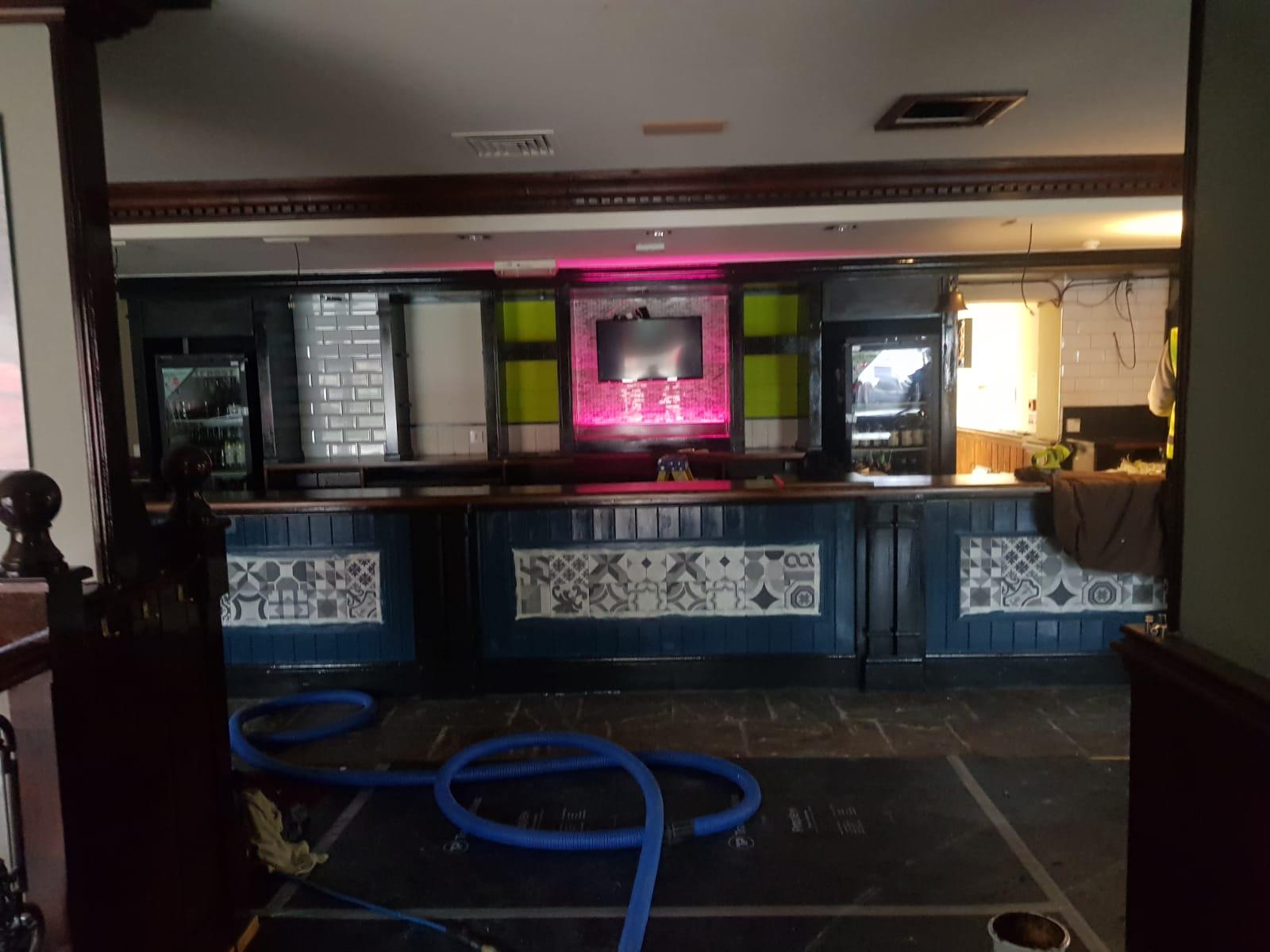 A bar is being cleaned with a hose.