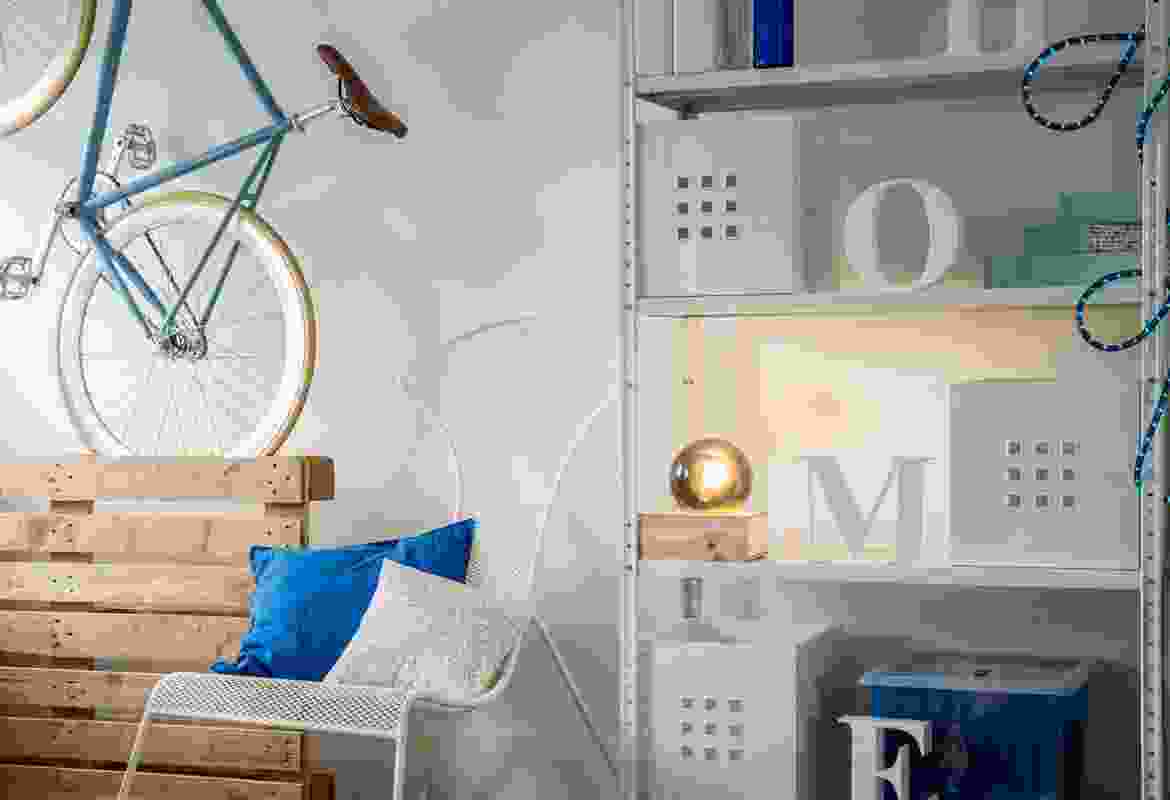 A room with a bicycle hanging on the wall.