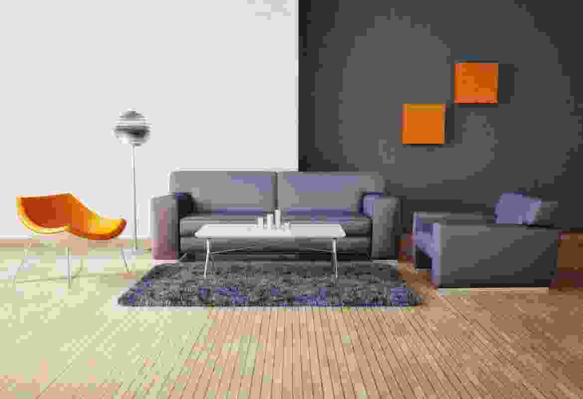 A living room with a grey couch and orange chairs.