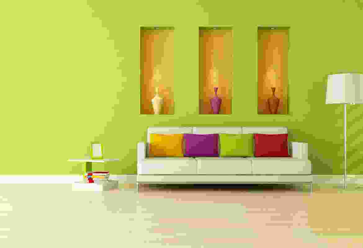 A colorful living room with green walls.