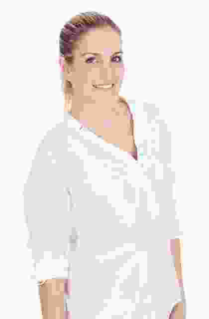 A woman in a white shirt is posing for a photo.