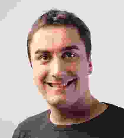 A smiling man wearing a black t - shirt.