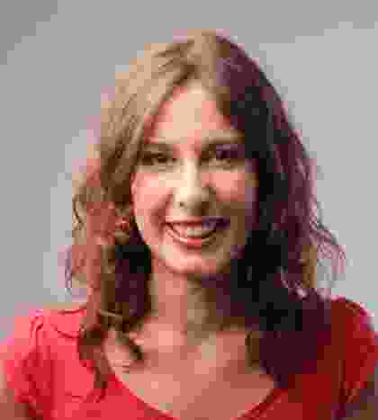 A woman in a red top smiling for the camera.