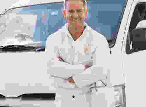 A man standing in front of a white van.