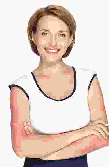 A smiling woman with her arms crossed.