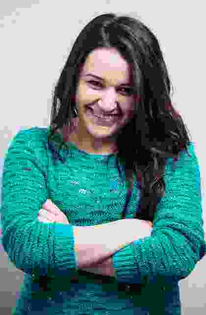 A smiling woman in a green sweater.