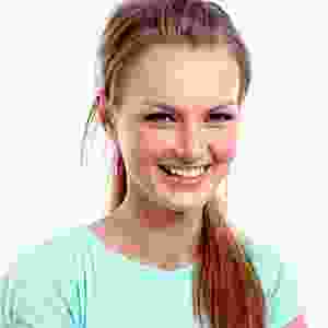 A girl in a blue shirt is smiling.