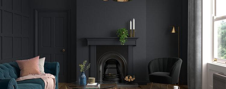A living room with black walls and blue furniture.