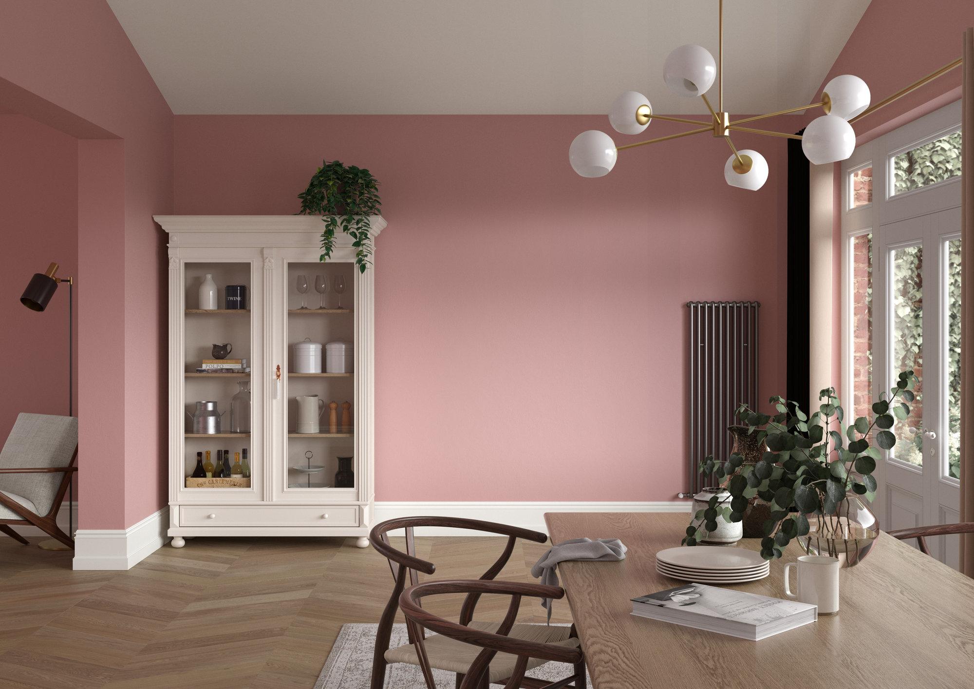 A living room with pink walls and wooden floors.