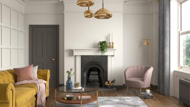 A living room with a yellow couch and a fireplace.