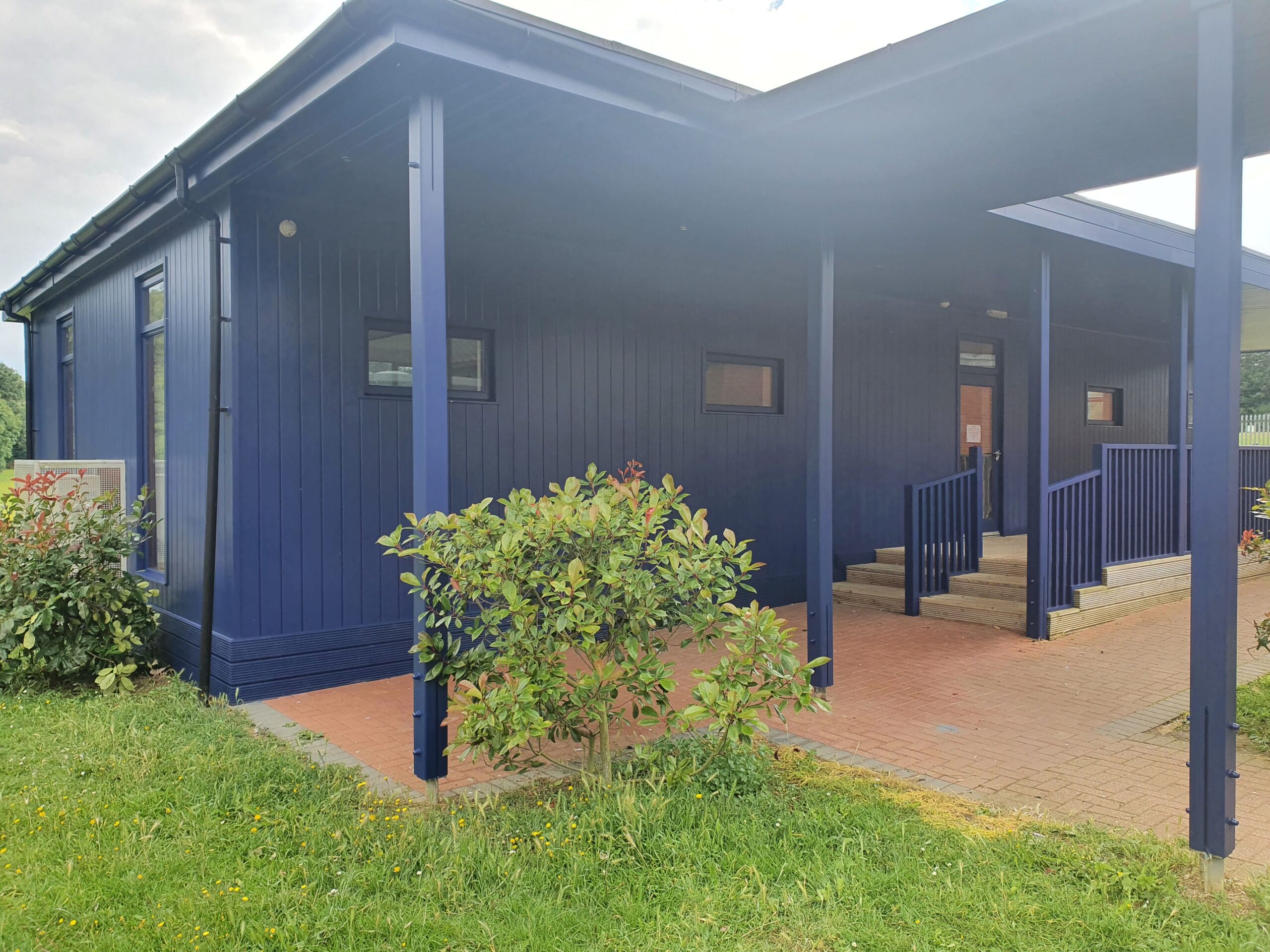 A blue building with a porch and steps.