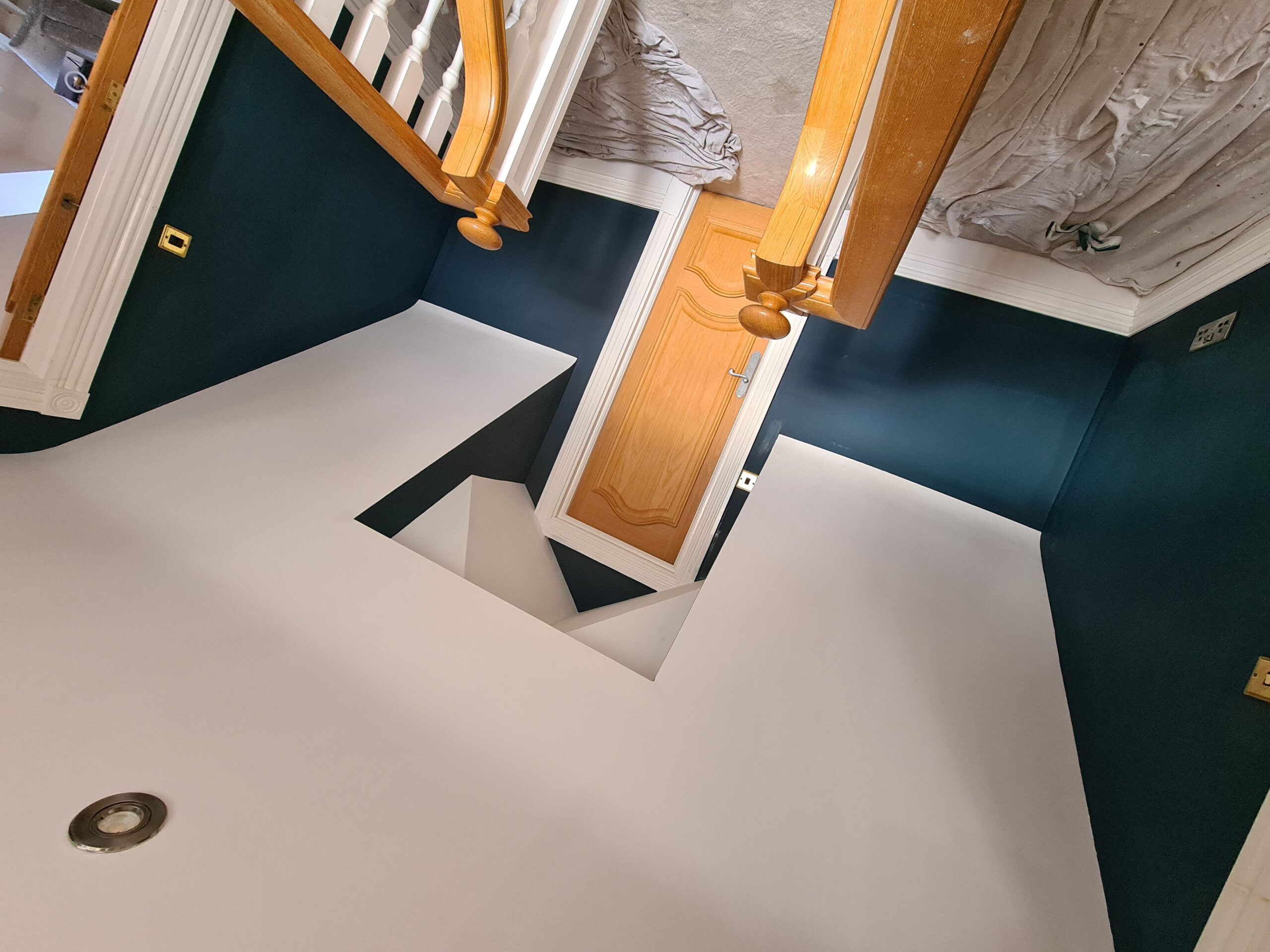 A view of a staircase with blue walls and a wooden floor.