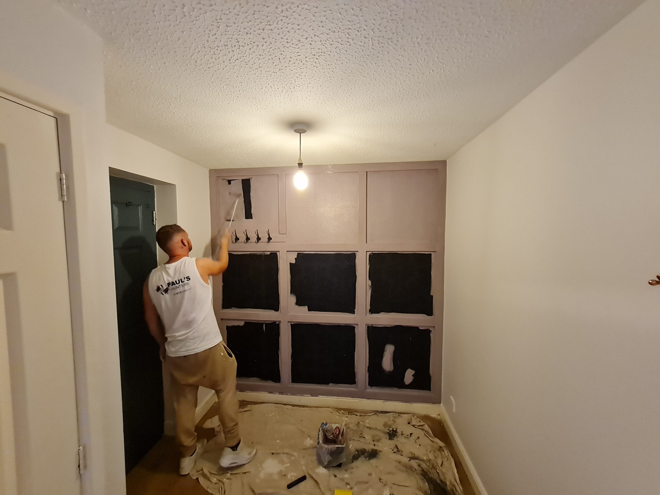 A man painting a room with cream color