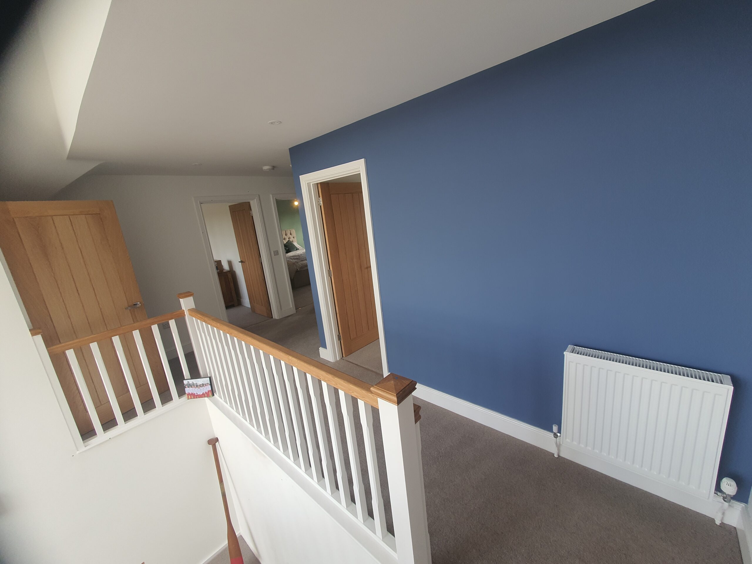 A blue wall with white railings and wooden railing.