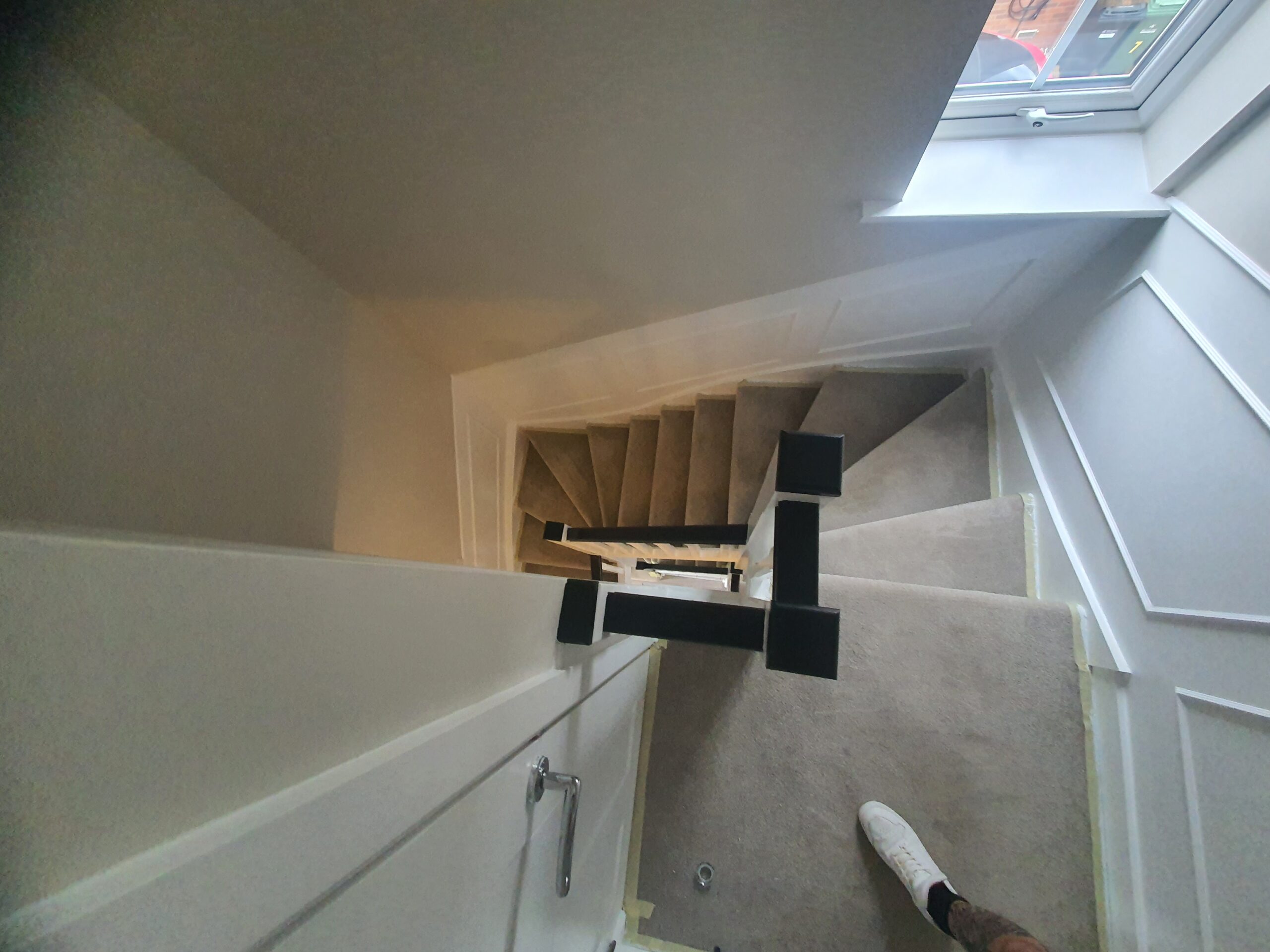 A person is holding onto the handle of a stair lift.