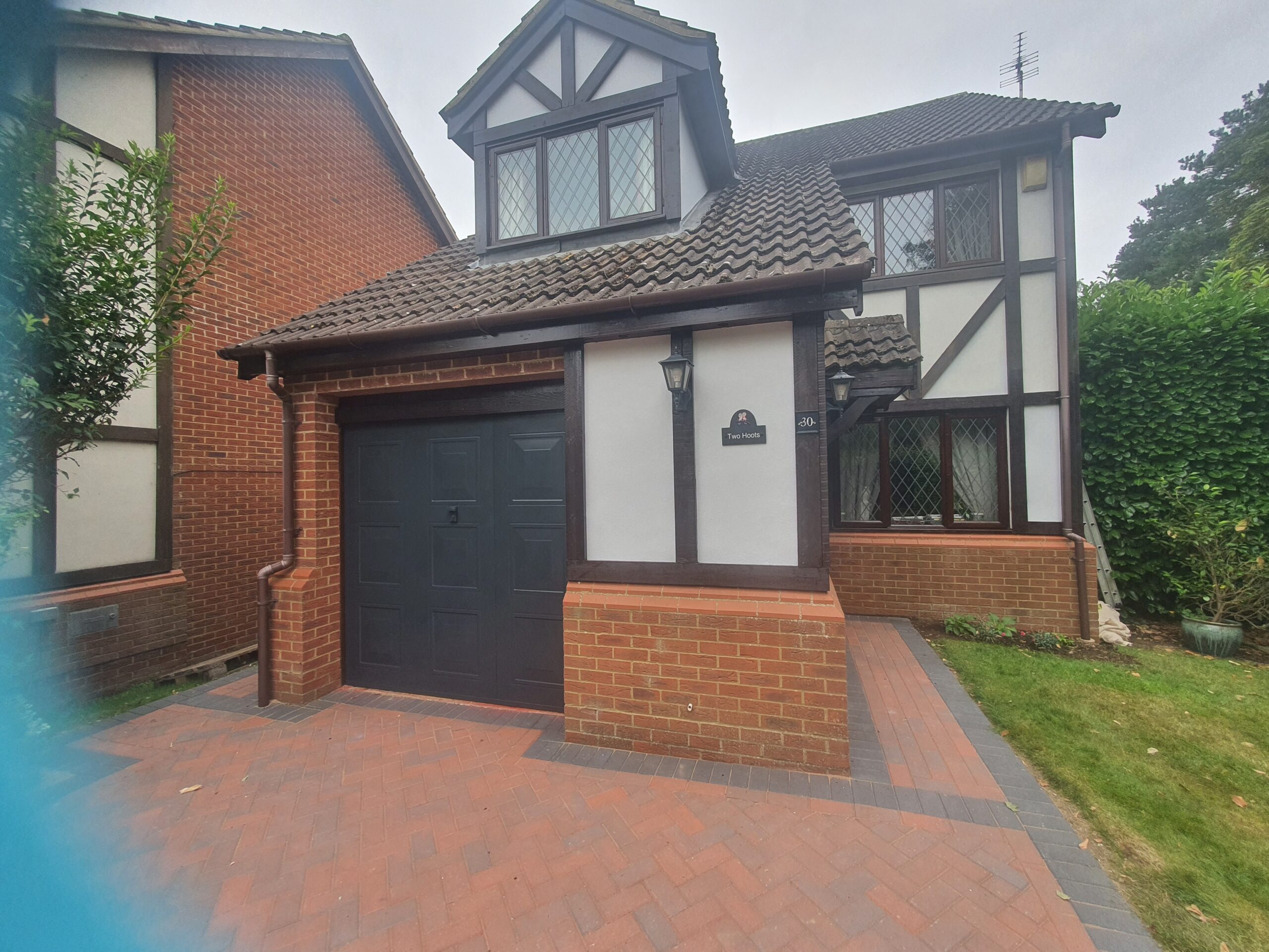 A house with a garage and brick driveway.