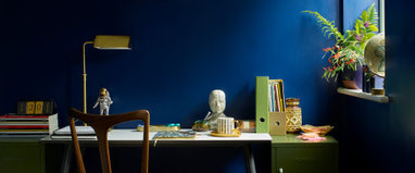 A room with blue walls and a desk.