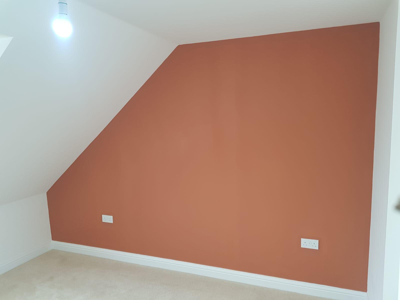 A room with an orange wall and white ceiling.