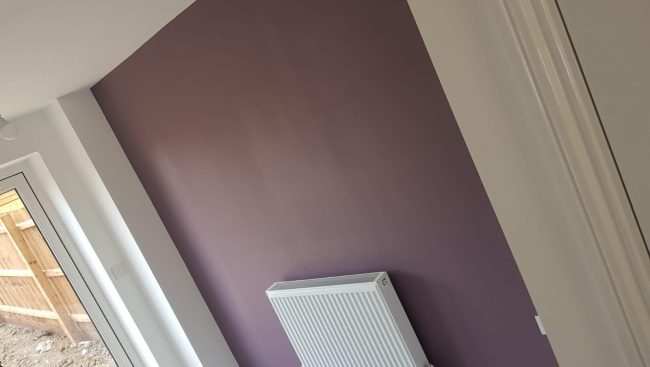A room with purple walls and a radiator.