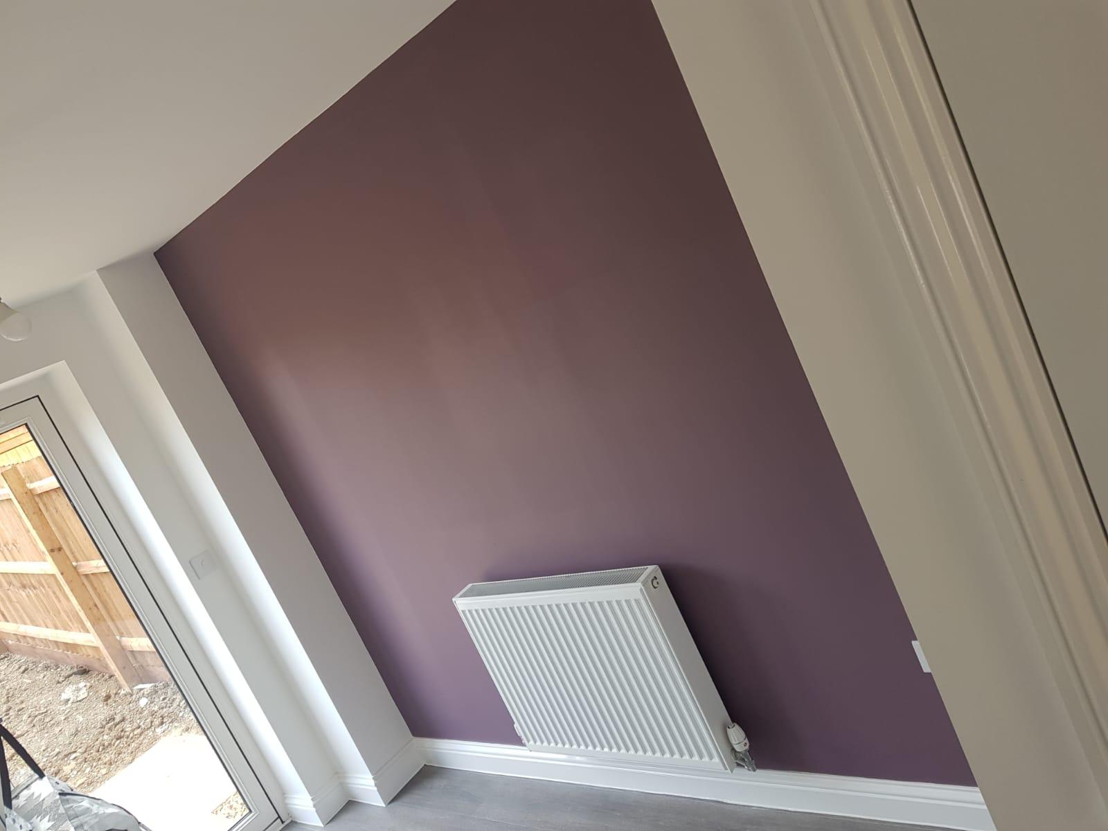 A room with purple walls and a radiator.