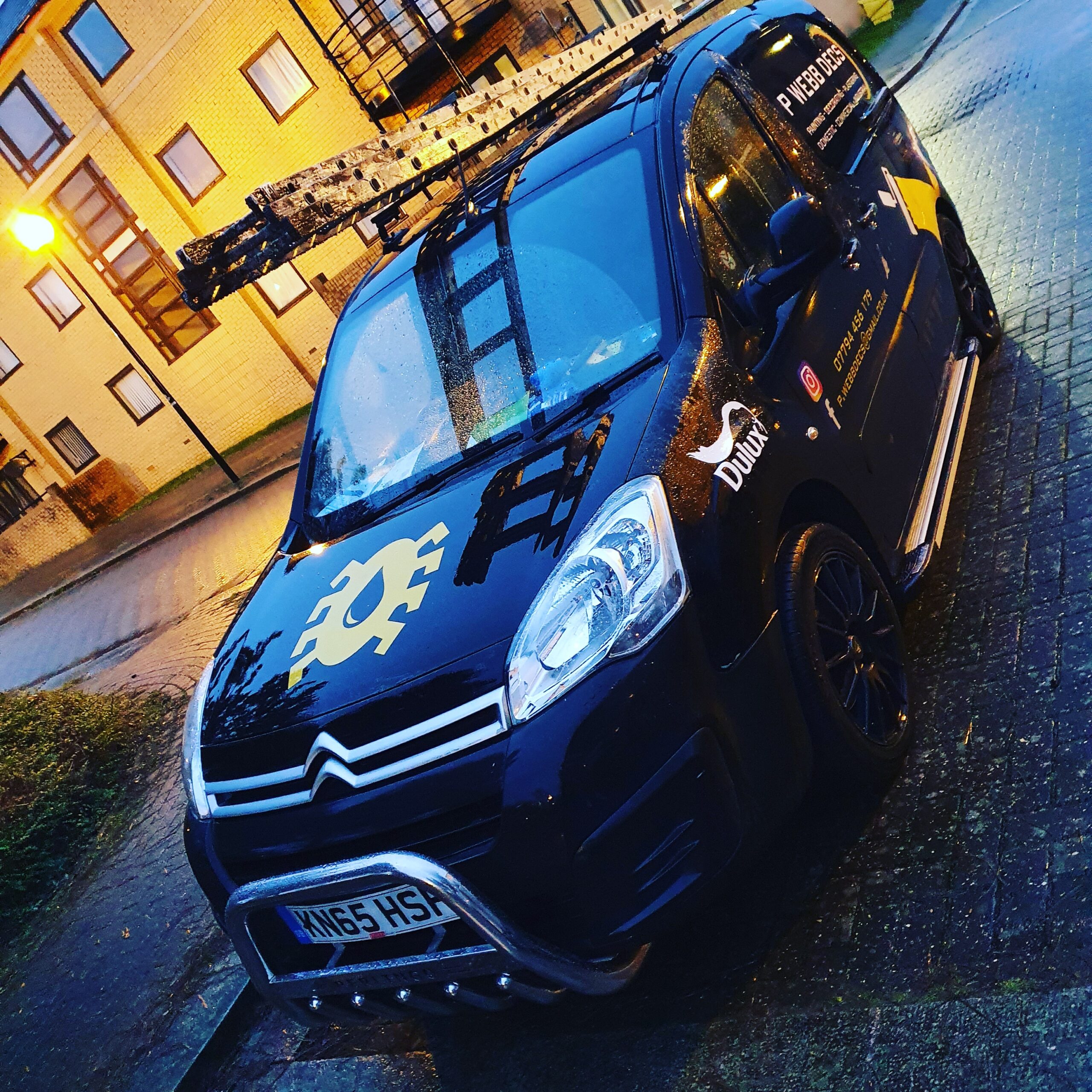 A black van parked in front of a building.