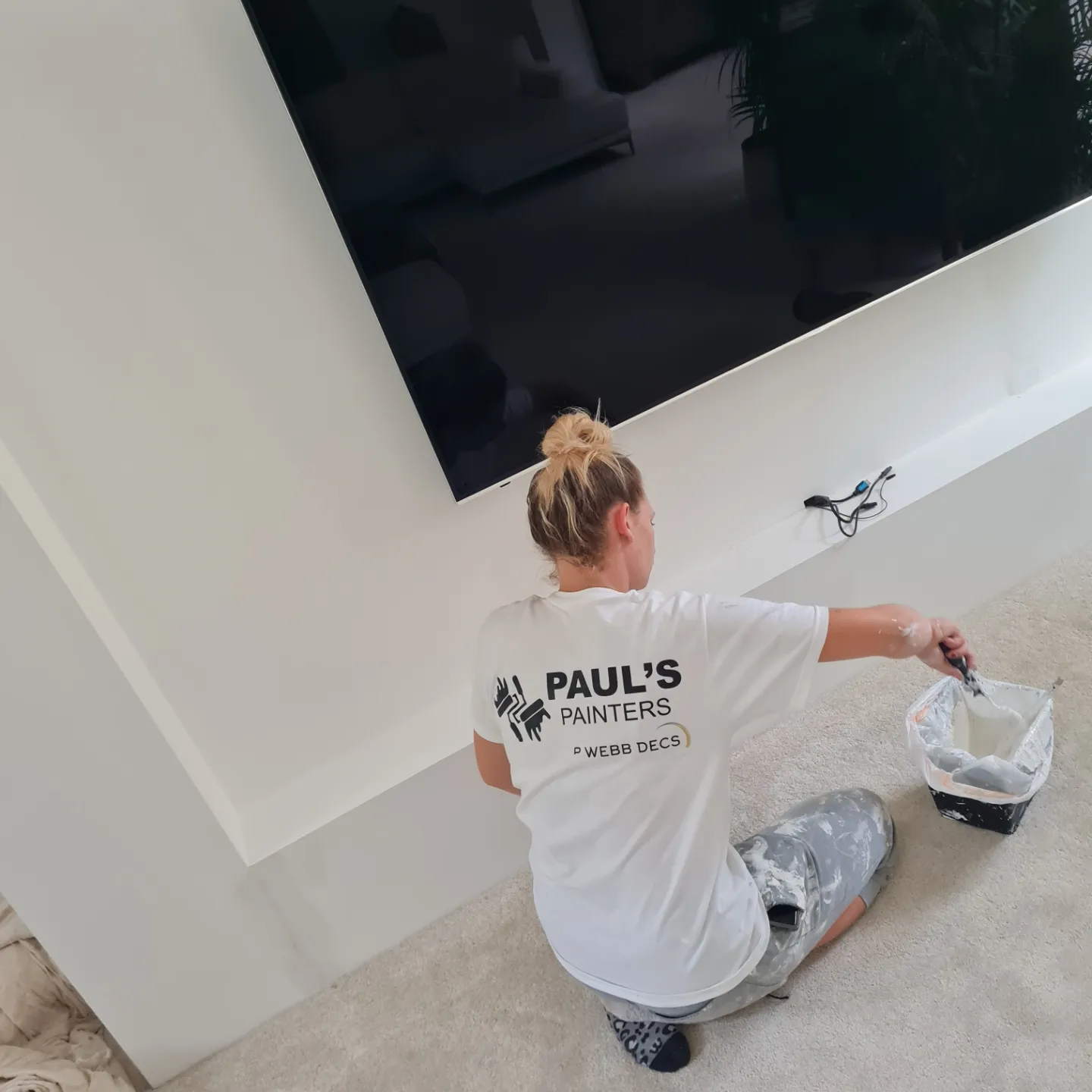Pauls Painters worker painting, a white wall