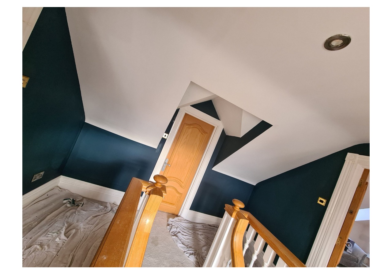 A room with blue walls and a wooden staircase.