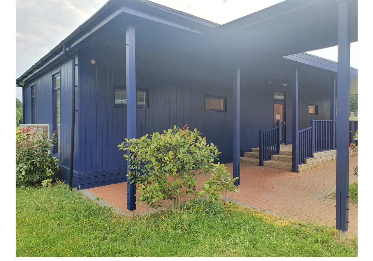 A blue building with a porch and steps.