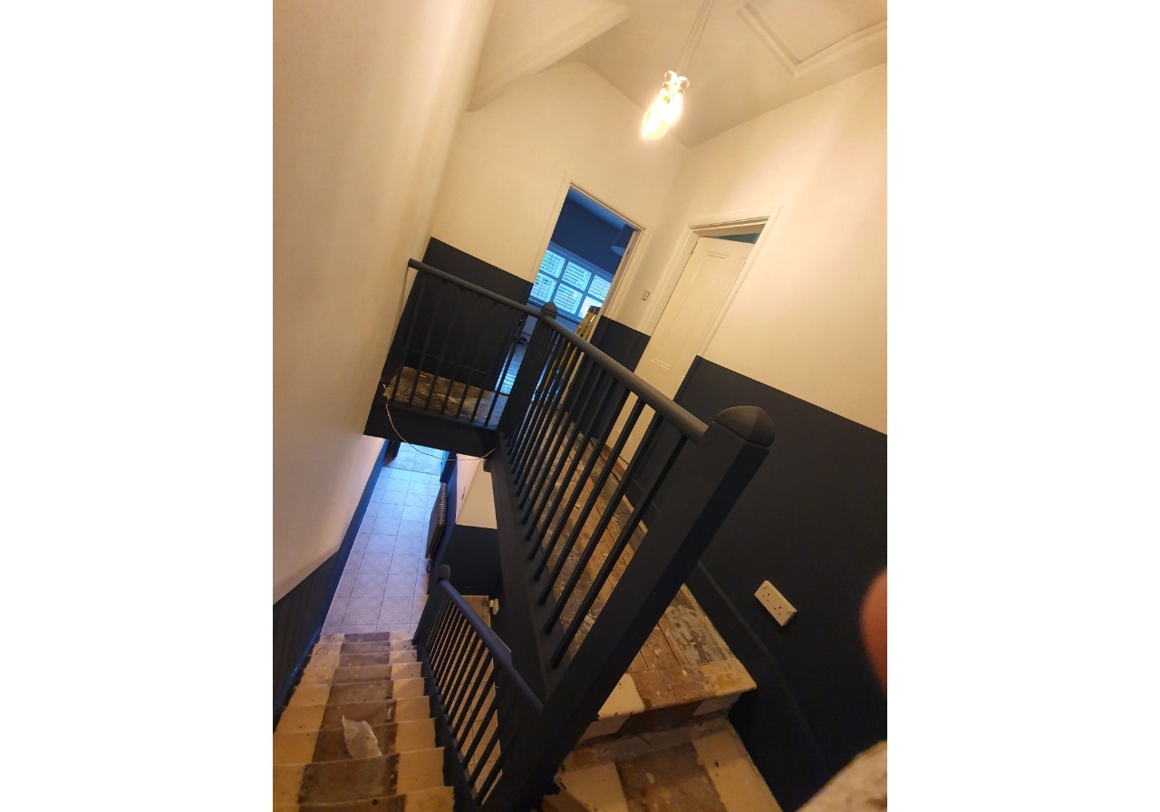 A stairway leading to a room with a black railing.