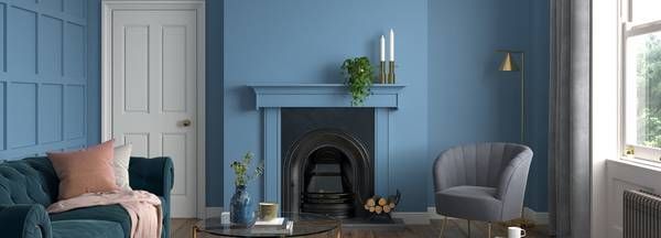 A living room with blue walls and a fireplace.