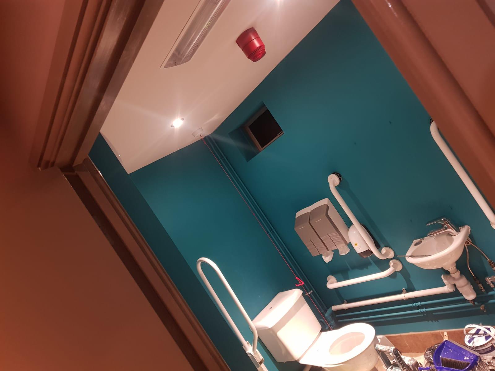 A bathroom with blue walls and a toilet.