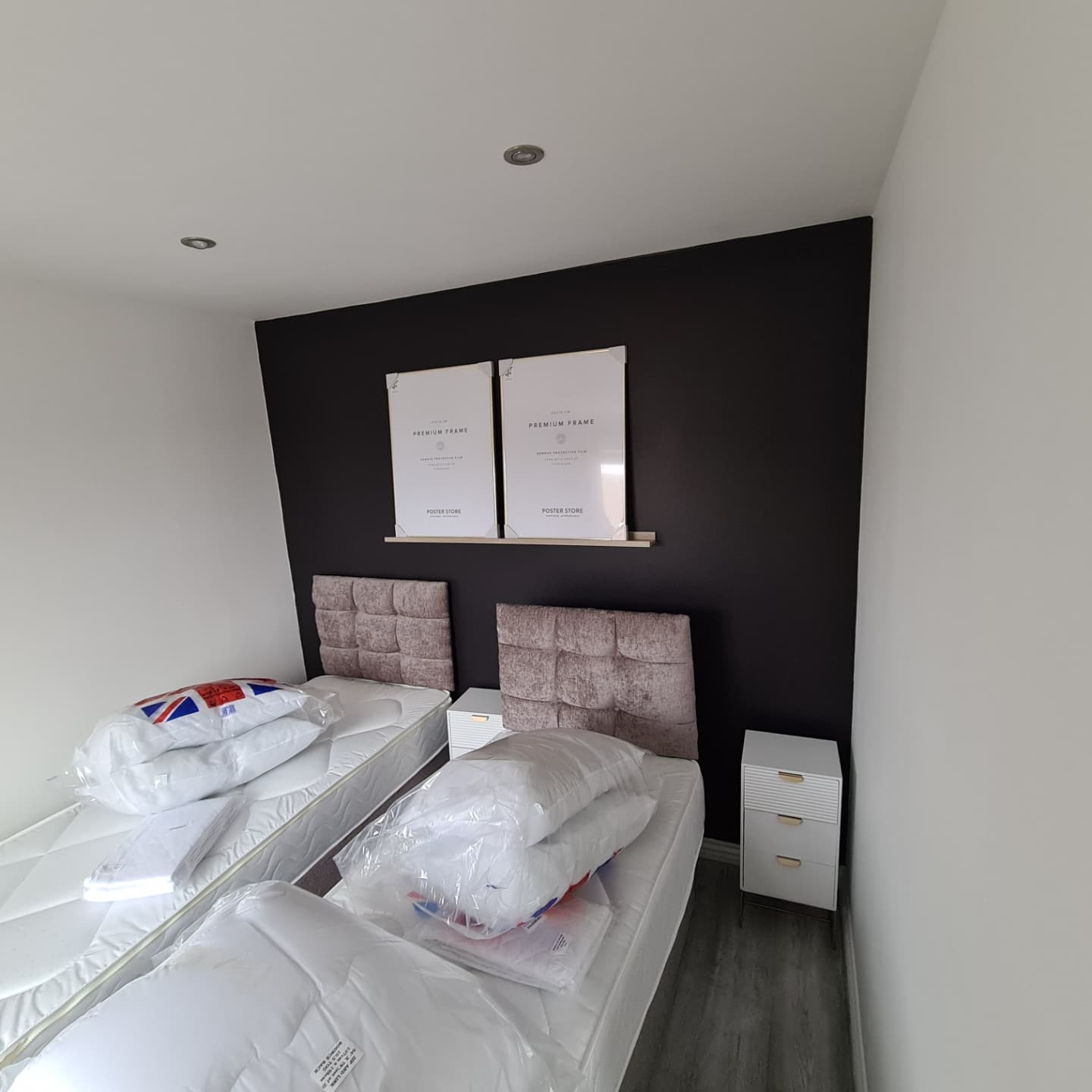 Two beds in a small room with black walls.
