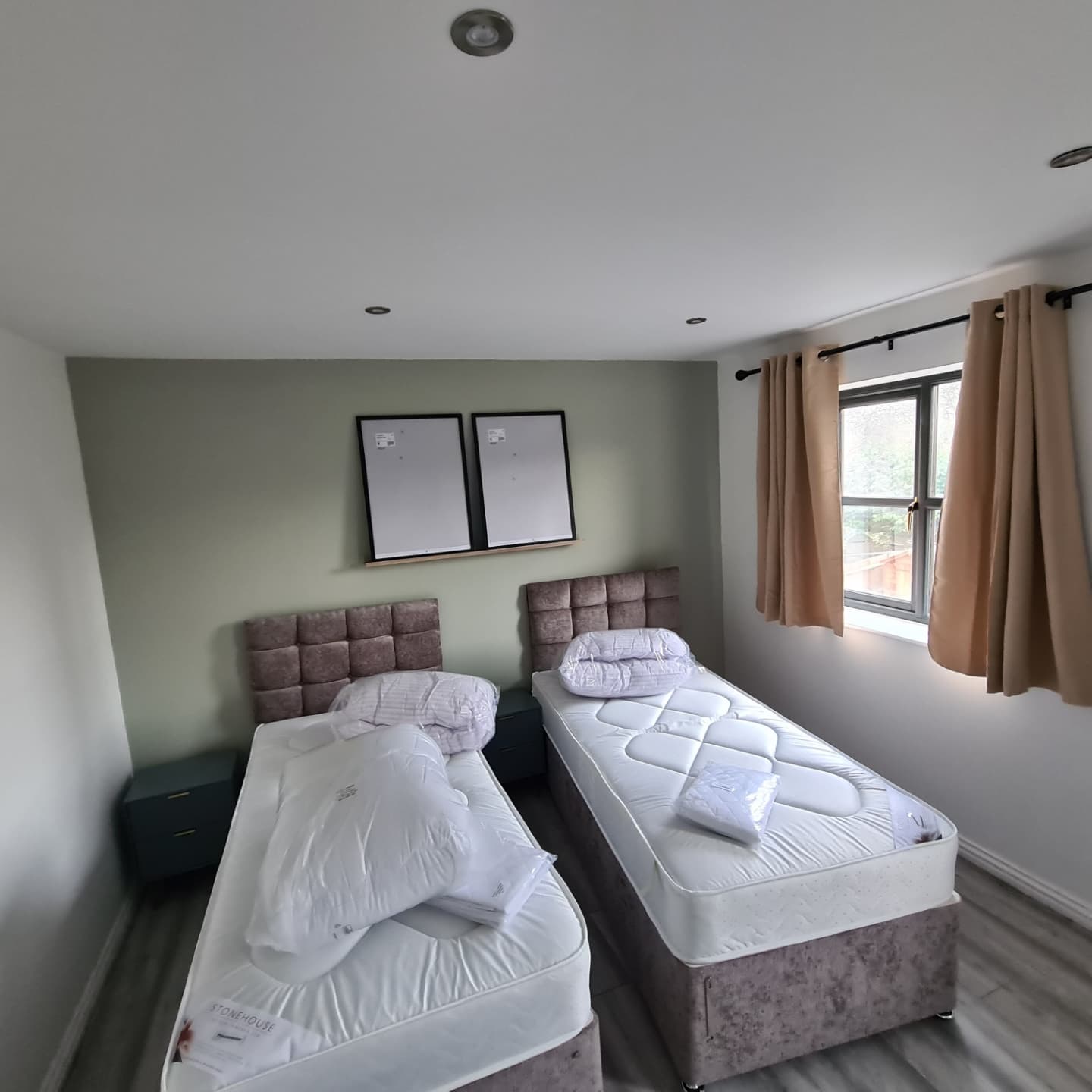 Two beds in a small room with a window.