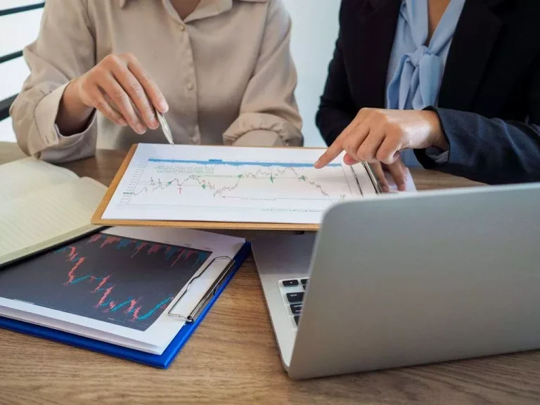 Two people analyzing financial charts and graphs.
