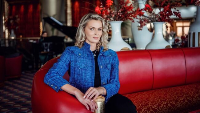 A woman sitting on top of a red couch.