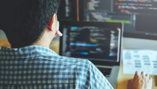 Person coding on a laptop computer.